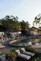 Una piscina al aire libre, camas de piscina con cargo, sombrillas