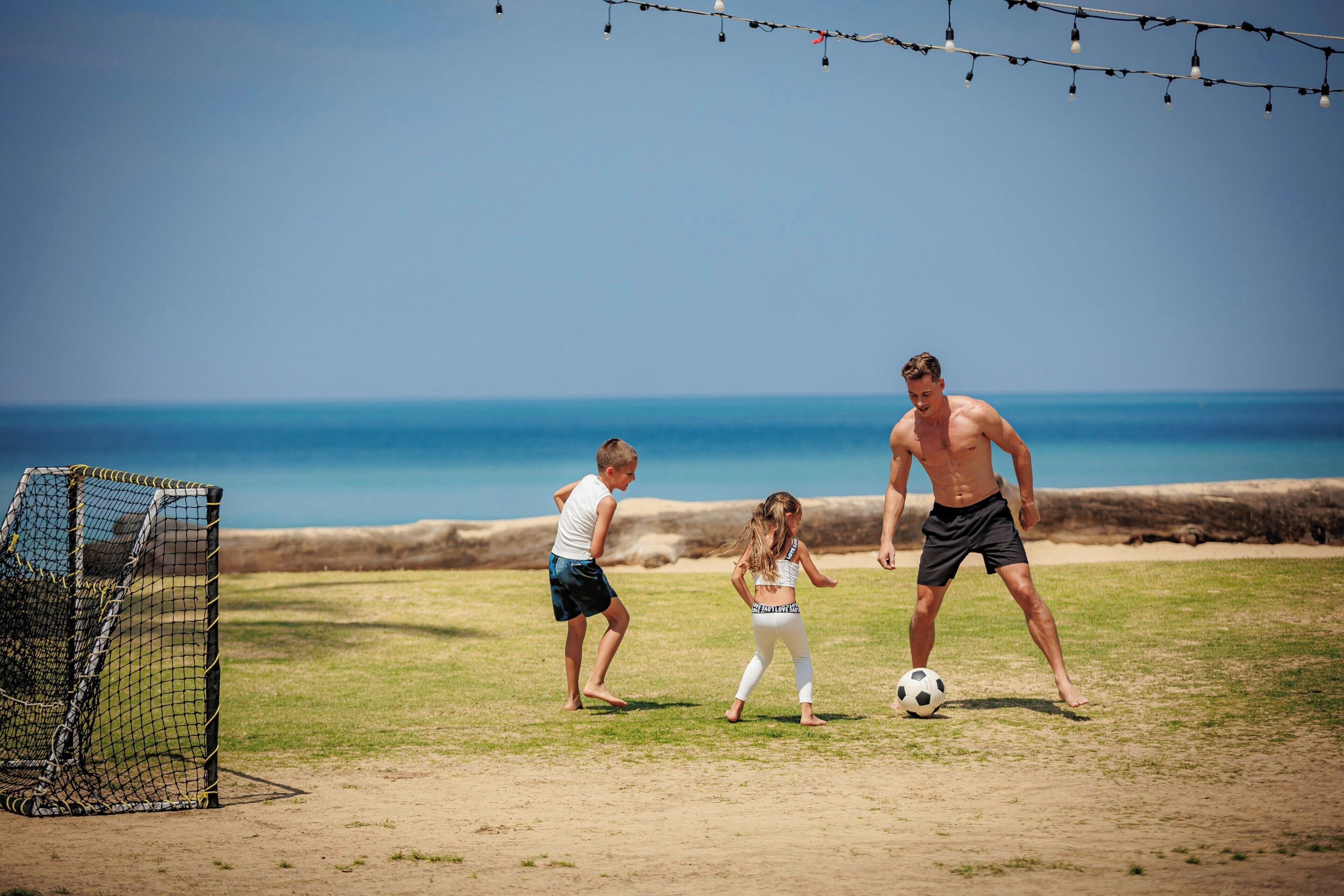 Ein Fußballspiel am Strand, mit Tor und Netz.