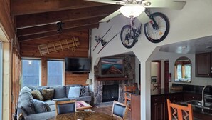 A cozy living room with a fireplace, a television, and a dining area with a round table and chairs. - CLOSEST HOME TO A CHAIRLIFT & HIKING ON THE PLANET! SLEEPS 8, CLEAN, WIFI, VIEWS (Stateline)