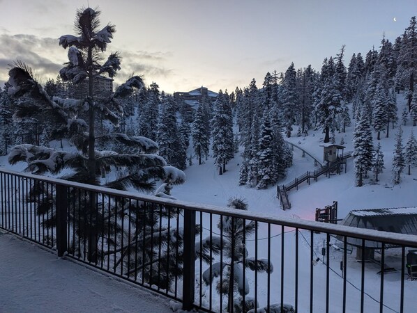 A snowy mountain landscape with a ski lift and a small cabin.