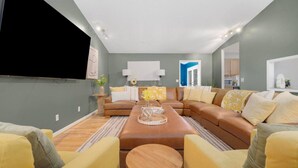 Ein modernes Wohnzimmer mit einer Eckcouch, gelben Sessel und einem Couchtisch.