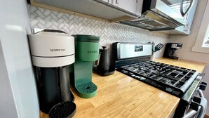 A kitchen with a Breville coffee maker, a Keurig, and a stove.