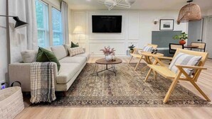 Una sala de estar moderna con un sofá, una mesa de centro y sillas de madera.