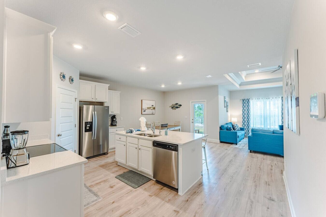 A modern kitchen with white cabinets, stainless steel appliances, and a central island.