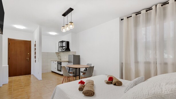 A hotel room with a bed, a small kitchenette, a dining area, and a bathroom. - Alessia's Flat - Borgo Palazzo 005 (Bergamo)