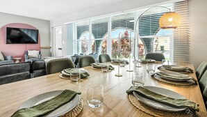 A dining area with a long wooden table set for four, surrounded by chairs. - Tranquil Waterfront • Enclosed pool • Kayaks (Oakland Park)