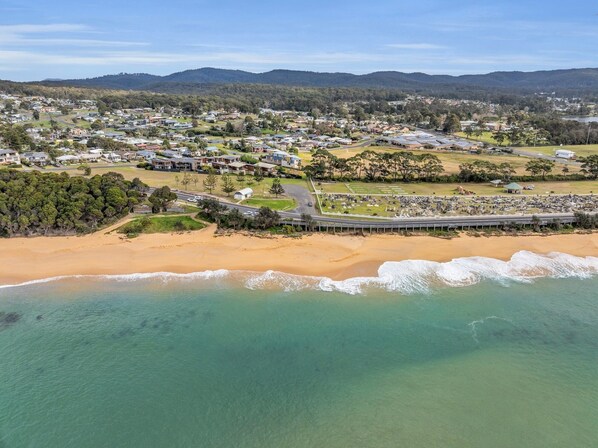 An aerial view of a coastal town with a beach, residential areas, and a large park. - Saltwater Apartments - 2 Bedroom (Eden)
