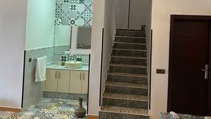 A staircase leading to a second floor, a kitchen area with patterned tiles, and a patterned floor. - Villa with swimming pool not overlooked (Marrakech)