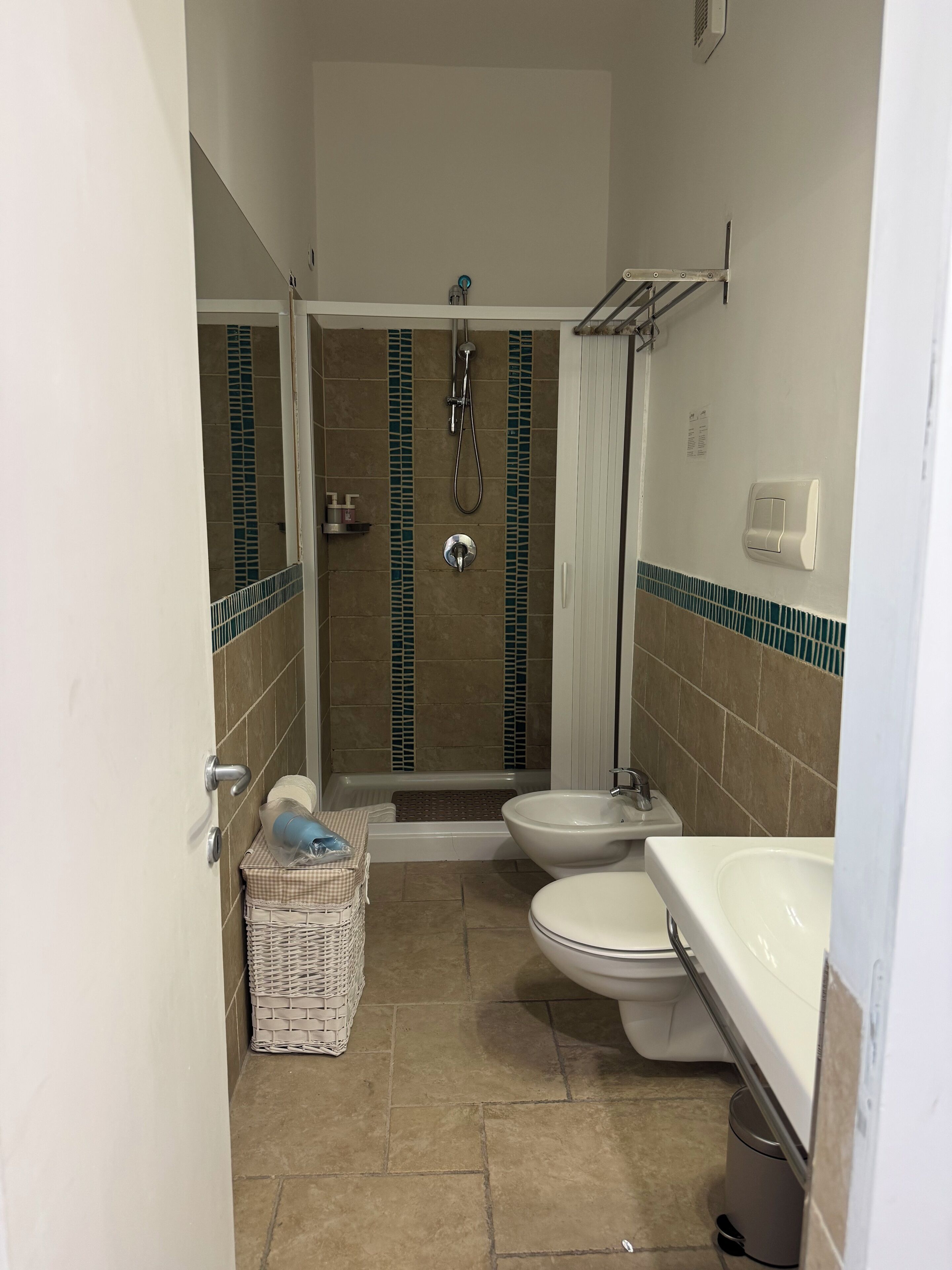 A bathroom with a shower, toilet, and sink.