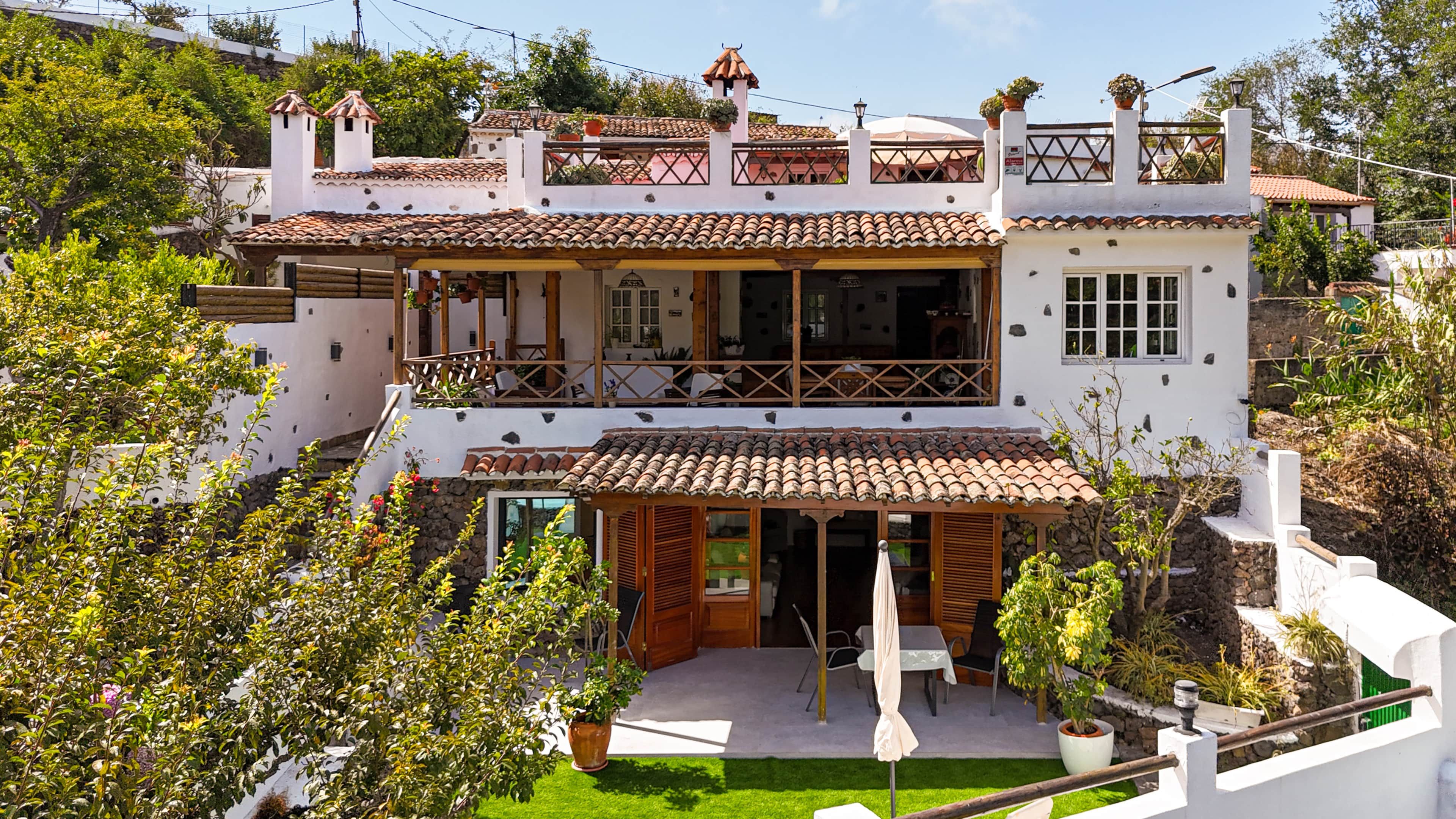 Un bâtiment à deux étages doté d’un balcon, d’une terrasse couverte et d’un jardin.