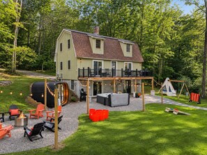 A house with a deck, outdoor seating, and a fire pit. - Family Retreat • Sauna • Hot Tub • Games • Peloton (Bartlett)