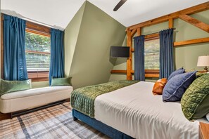 A bedroom with a bed, a sofa, a television, and a window with curtains. - Family Retreat • Sauna • Hot Tub • Games • Peloton (Bartlett)