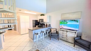 Un appartement moderne comprenant une cuisine, un coin repas et un salon.