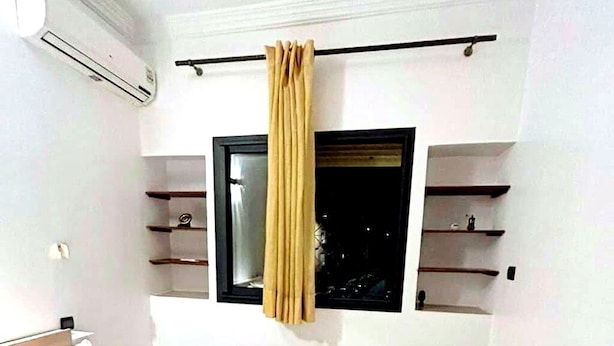 Une chambre à coucher avec un lit, une fenêtre et des étagères intégrées.