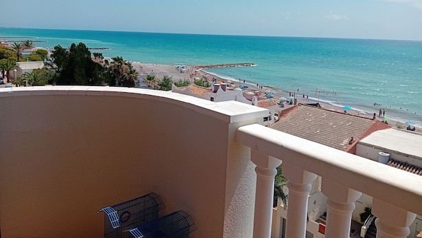 Ein Balkon mit Blick auf Strand und Meer.