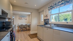 Una cocina moderna con zona de comedor, que cuenta con un amplio ventanal, microondas y cafetera.