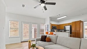 A modern living room with a sofa, a coffee table, and a ceiling fan.