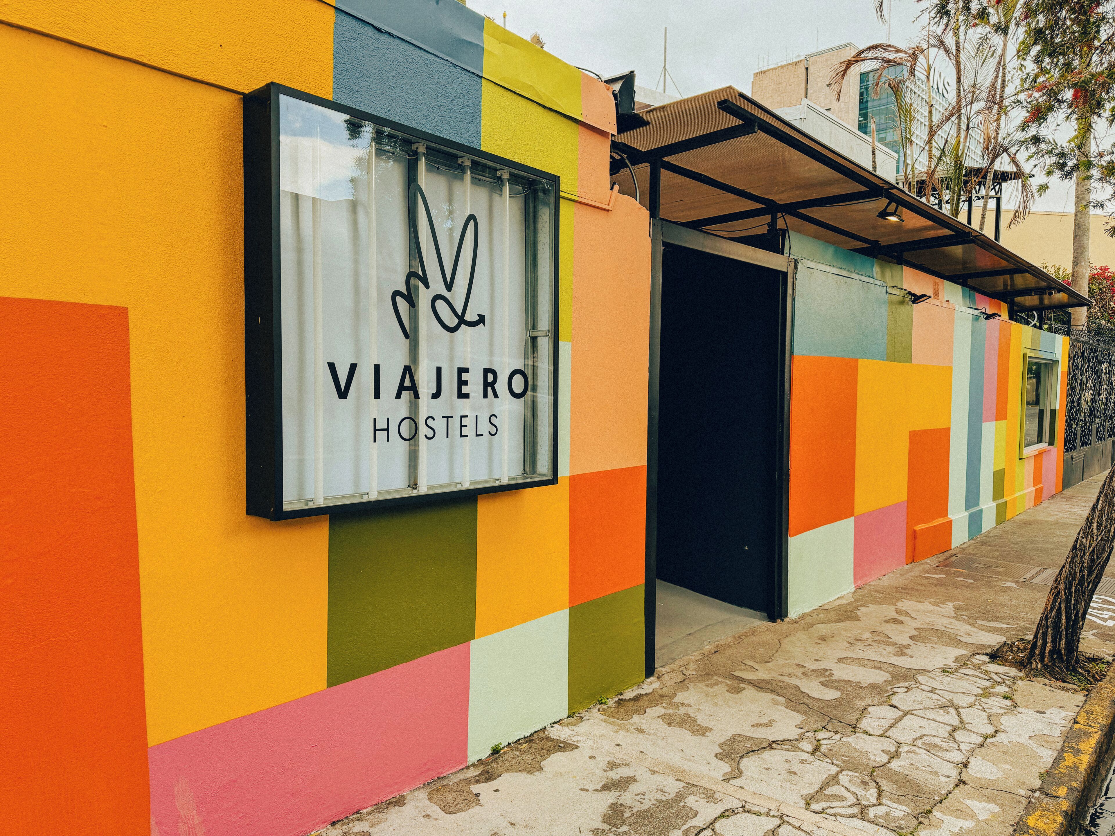 A colorful hostel exterior with a large sign reading 'VIAJERO HOSTELS.'