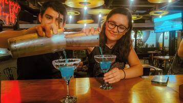 A bar setting with two people preparing drinks.