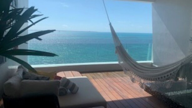 Un'amaca su un balcone con vista sull'oceano.