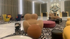 Un'ampia hall con comode sedute, una reception e un pannello decorativo.