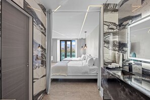 Une chambre d’hôtel moderne avec un grand lit, une salle de bain avec un miroir et une vue sur la ville.