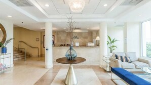 A spacious lobby with a round table, a staircase, and a reception area.