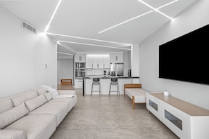 A modern living room with a sofa, a coffee table, and a TV.