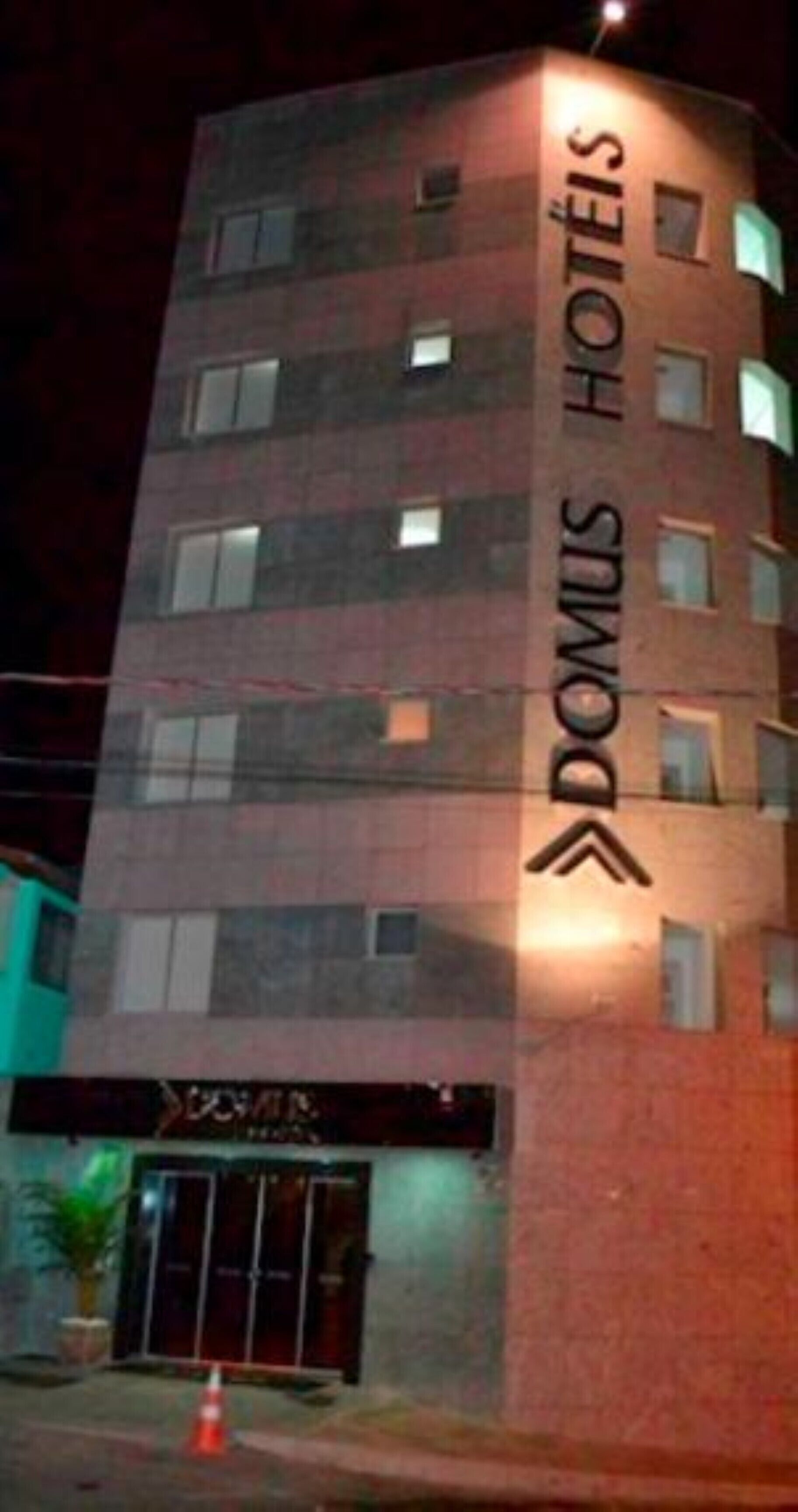 En hotellbyggnad med flera våningar, med en tydlig skylt med texten ”DOMUS HOTELS” på fasaden.