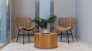 A room with two wicker chairs, a wooden table, and a potted plant. - 2 rooms Las Lomitas (Lomas de Zamora)