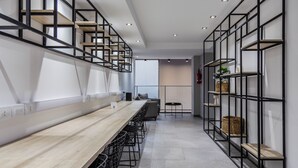A modern kitchen with a long wooden countertop, black metal shelving, and a staircase leading to an upper level. - 2 rooms Las Lomitas (Lomas de Zamora)