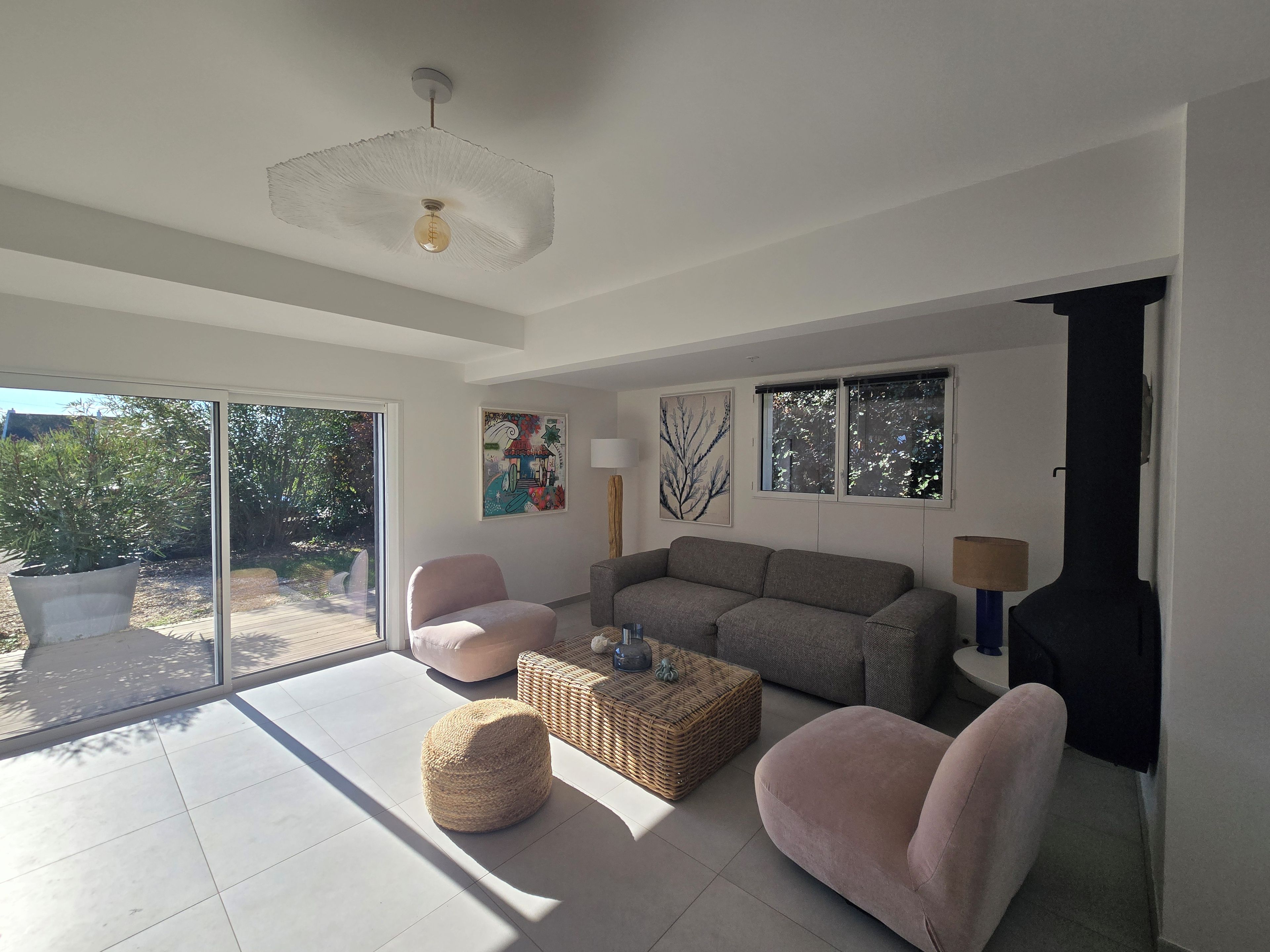 A modern living room with a sofa, two armchairs, a coffee table, and a fireplace.