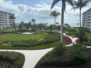 Un resort con un paseo empedrado, palmeras y vistas al mar.