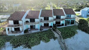 A beachfront property with multiple two-story buildings, each featuring balconies and a patio area. - Sea Breeze Bungalow (Melbourne Beach)