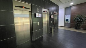 Een moderne liftruimte met metalen wanden en een potplant.