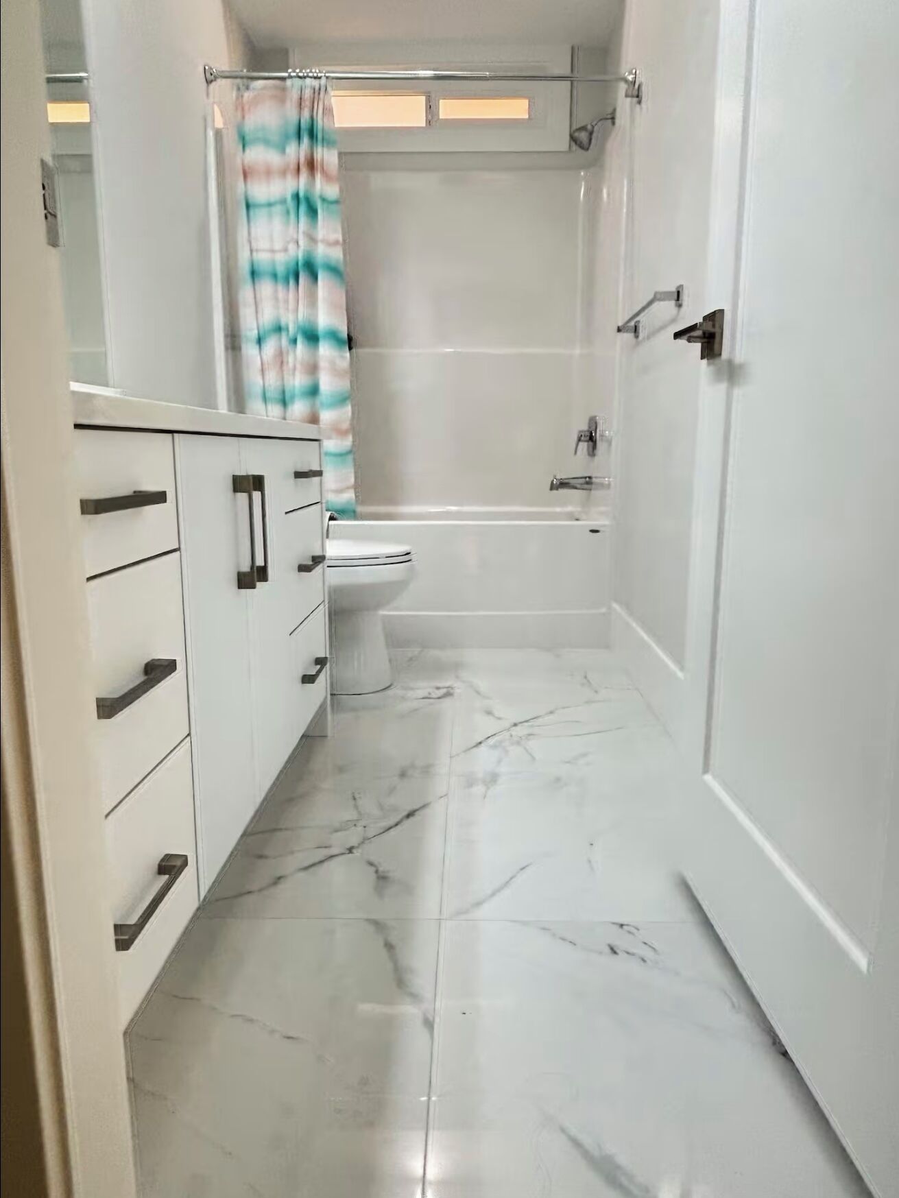 A bathroom with a toilet, a bathtub, and a shower area.