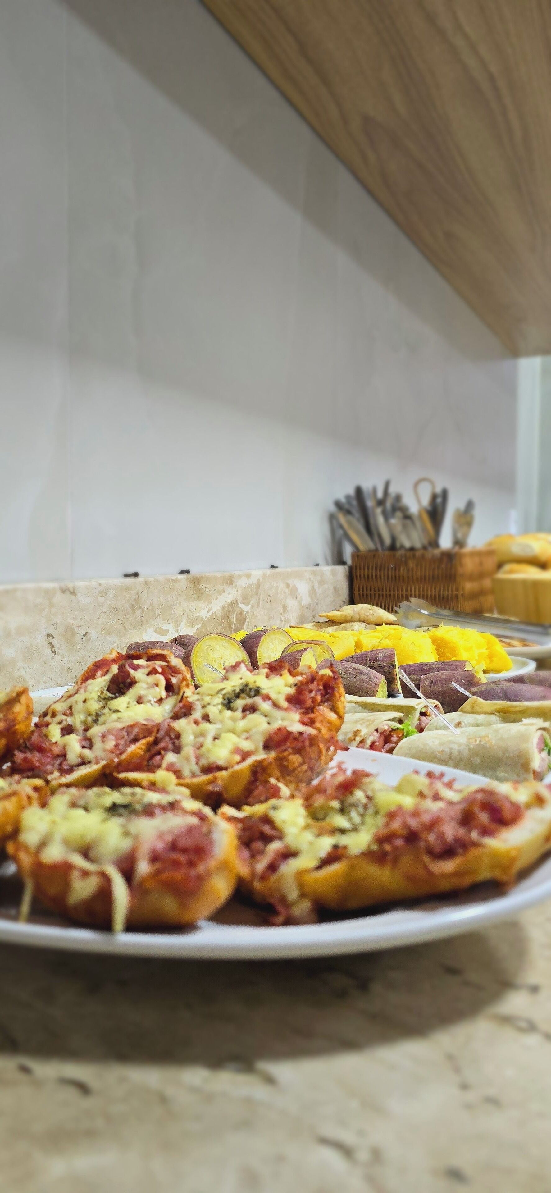 A kitchen counter with a variety of baked goods, including pizzas and pastries.