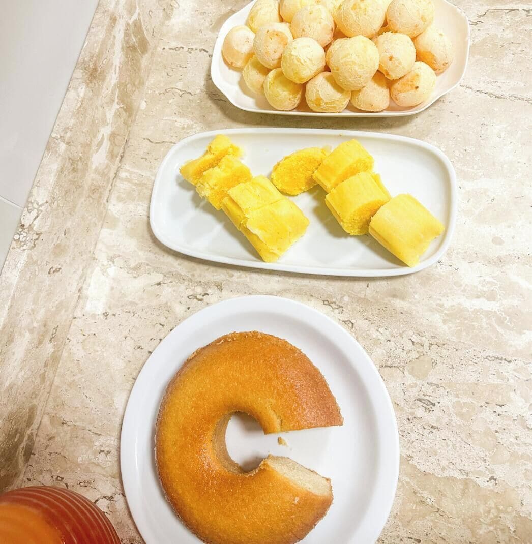 Ein Tisch mit Käsebrötchen, Käsebällchen, Ananasstücken und einem Kuchen.