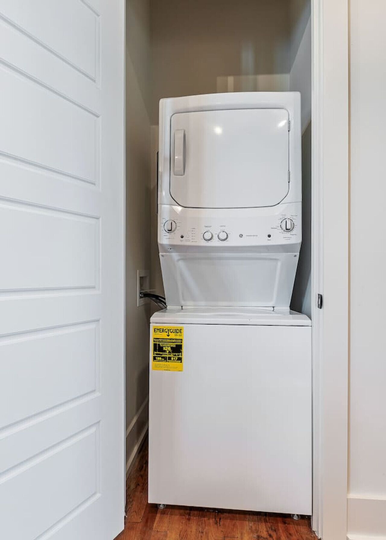 Un appareil compact combinant lave-linge et sèche-linge, doté d’un panneau de commande et d’une étiquette d’efficacité énergétique jaune.