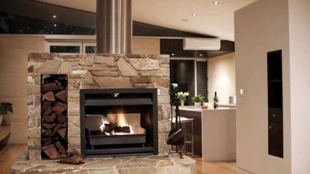 A modern kitchen with a stone fireplace, a bar area, and a large window. - Selador- Couples Bush Retreat & Close To Town (Margaret River)