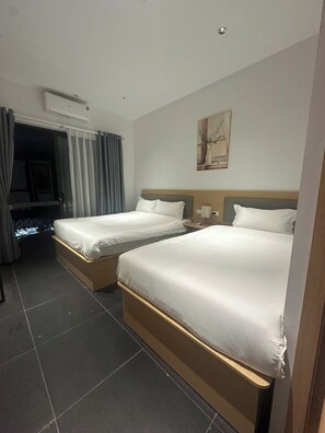 A hotel room with two beds, a window with curtains, a painting on the wall, and a ceiling light. - Starlight Hotel Hanoi (Ha Noi)