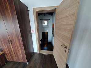 Un pasillo con un armario de madera y una puerta de madera que da a una habitación.