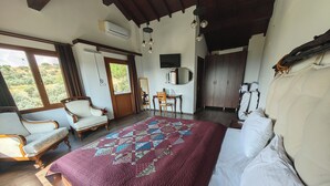 Un dormitorio con una cama grande, dos sillones, un escritorio y un guardarropa.