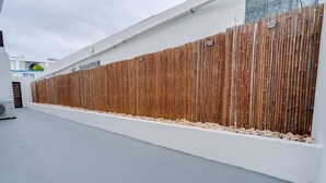 Un bâtiment moderne à l’extérieur blanc, agrémenté d’une clôture en bambou.