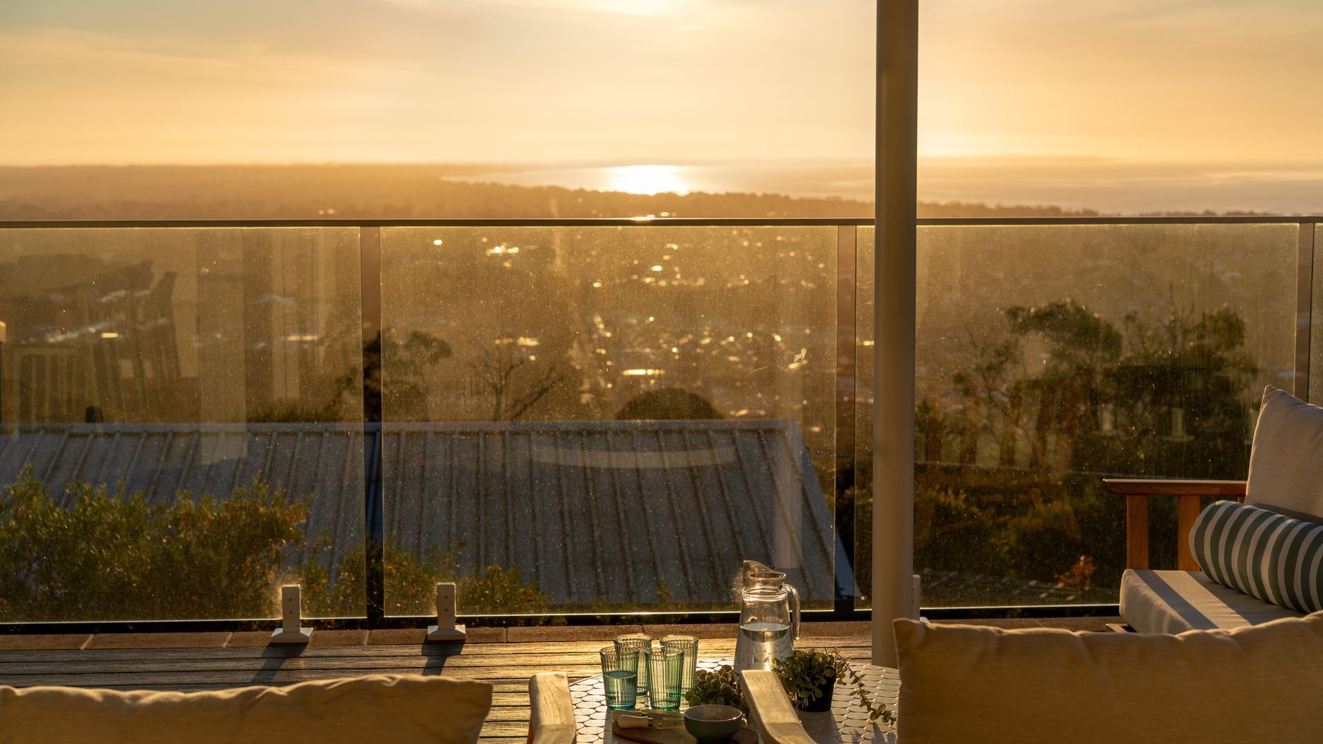 En balkon med udsigt over bybilledet i solnedgang.