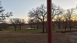 A park with a concrete structure, trees, and a grassy area. - Redbud Honey - Country Cabin away from it all (Lone Grove)