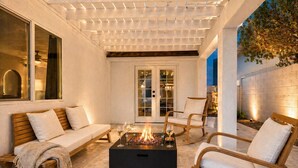 An outdoor patio with a fire pit, seating, and a pergola. - Modern Scottsdale Oasis Near Old Town–Pool, Waterfall, Glam Room & Putting Green (Scottsdale)