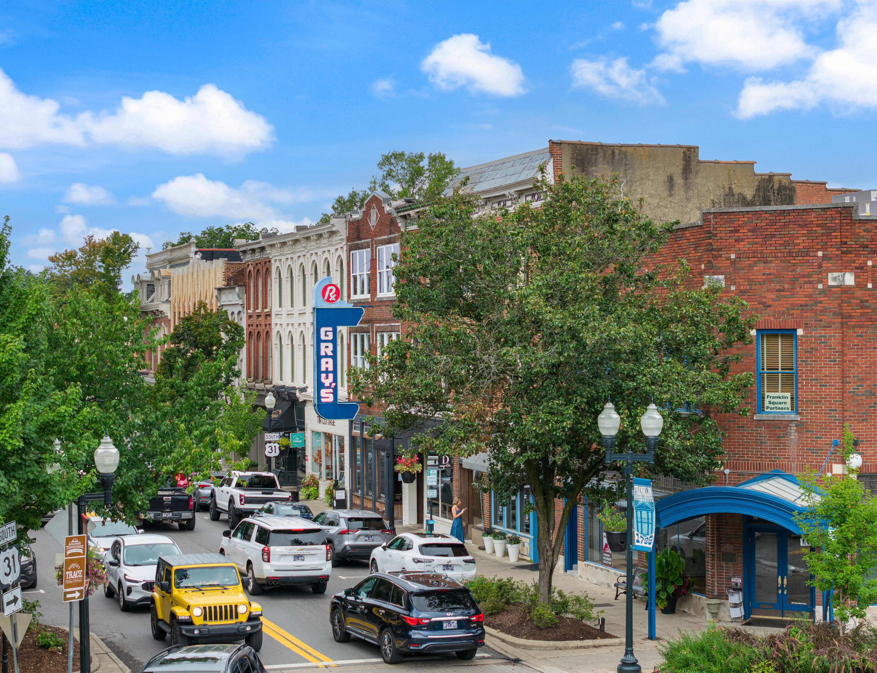 Une vue de rue présentant divers bâtiments, dont un panneau bien visible pour « Grays » et un panneau de « Franklin Square Partners ».