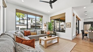 A modern living room with a sofa, coffee table, and large windows. - Luxury Dual-Home Retreat w/ Pool in Austin’s Coveted downtown Travis Heights! (Austin)