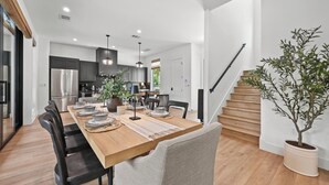 A modern kitchen with dark cabinets, stainless steel appliances, and pendant lighting. - Luxury Dual-Home Retreat w/ Pool in Austin’s Coveted downtown Travis Heights! (Austin)